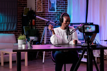 African american blogger filming online podcast show, talking to channel audience on camera. Female...