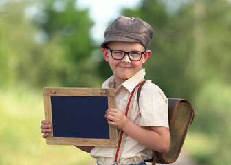 kleiner Schuljunge mit Kreidetafel