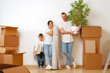 Fototapeta na wymiar Portrait of happy family with cardboard boxes in new house at moving day