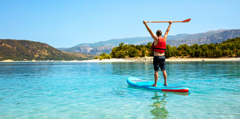 man having fun stand up paddling in lake