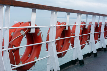 Lifebuoys hang on board a sea ferry floating on the waves