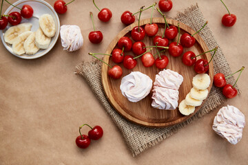 Natural sugar free vanilla marshmallows with banana and cherry taste on wooden plate. Healthy food, natural food