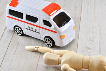 床に倒れている人形と救急車