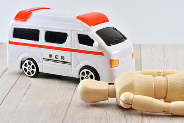 床に倒れている人形と救急車