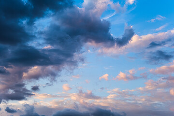 Beautiful evening sky with colorful clouds. Sunset sky with puffy clouds. Textured sky background