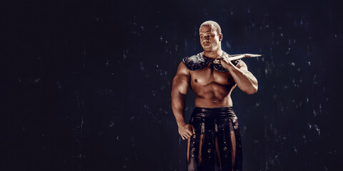 Obraz na płótnie Canvas Studio shot of muscular ancient warrior man posing with axe