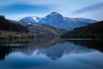 Fototapeta na wymiar Ibiur reservoir with Txindoki mountain as background, Basque Country in Spain