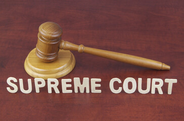 Supreme court decision concept. Words supreme court and wooden judge gavel.