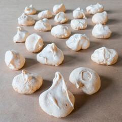 Homemade french milk-colored meringues on crumpled craft paper