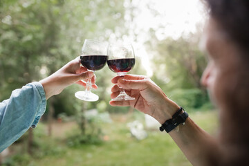 Hands couple woman and man drinking red wine from glasses outside