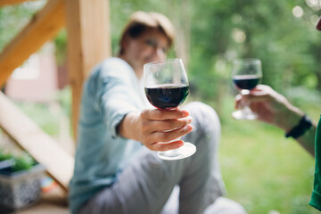 Hands couple woman and man drinking red wine from glasses outside