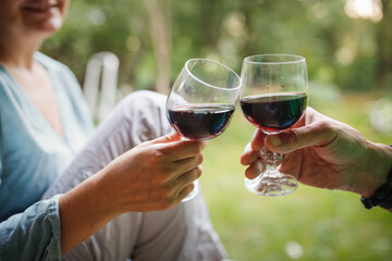 Hands couple woman and man drinking red wine from glasses outside