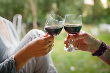 Hands couple woman and man drinking red wine from glasses outside