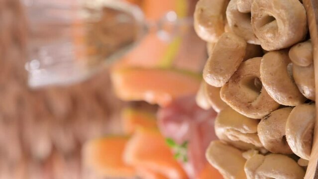 Tarallini-traditional Italian small bagels. Taralli. Delicious snack close-up on the table served. Selective focus. Antipasto for aperitif , Italians drinking wine. footage. vertical video