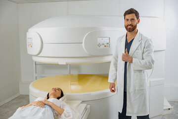 Radiologist on background of MRI or CT or PET Scan with patient showing thumbs up