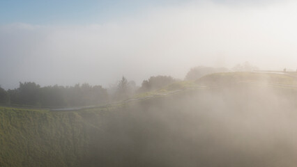 Thick fog drifting over volcanic crater at Mt Eden summit, Auckland