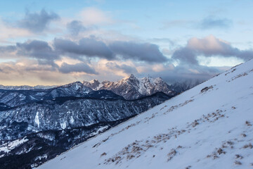 Winter peaks with fresh snow and clouds above it. 