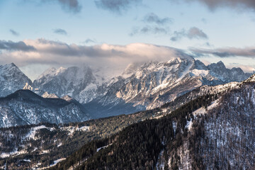 Fototapeta premium Winter peaks with fresh snow and clouds above it. 