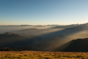 Foggy sunset in the mountains. Mist is covering the hills in the early evening.