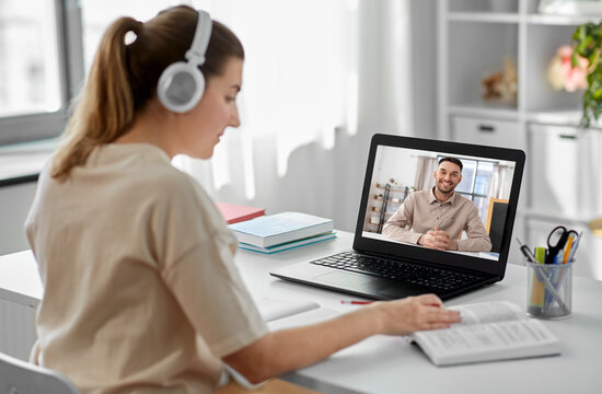 school, education and distance learning concept - happy smiling female student with teacher on laptop computer screen having video call or online class at home
