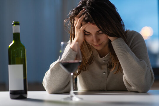 Alcoholism, Alcohol Addiction And People Concept - Drunk Woman Or Female Alcoholic Drinking Red Wine At Home