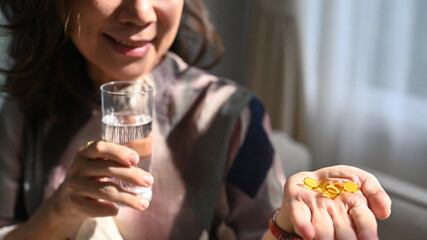 Middle aged woman having daily vitamins or diet supplements. Elderly healthcare, pharmaceutical...