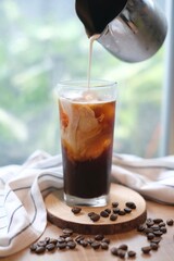 Making homemade Iced brew coffee with milk in the tall glass
