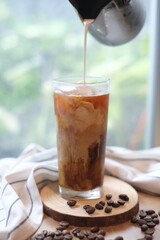 Making homemade Iced brew coffee with milk in the tall glass