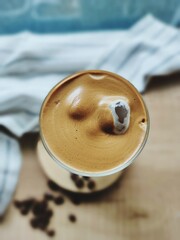 Top view of homemade iced coffee latte with coffee foam  in the tall glass
