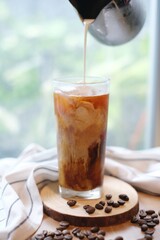Making homemade Iced brew coffee with milk in the tall glass