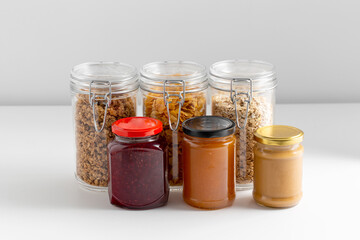 food, eating and storage concept - close up of preserves and cereals on table