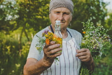 Fototapeta premium Old woman makes herbal tincture. Selective focus.