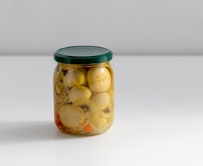 food, storage and preserve concept - close up of jar with pickled mushrooms on table