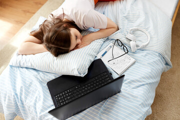 school, education and laziness concept - tired teenage student girl with laptop computer and...