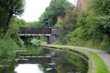 Rural Canal and Towpath with Bridge and Reflections in Still Water 