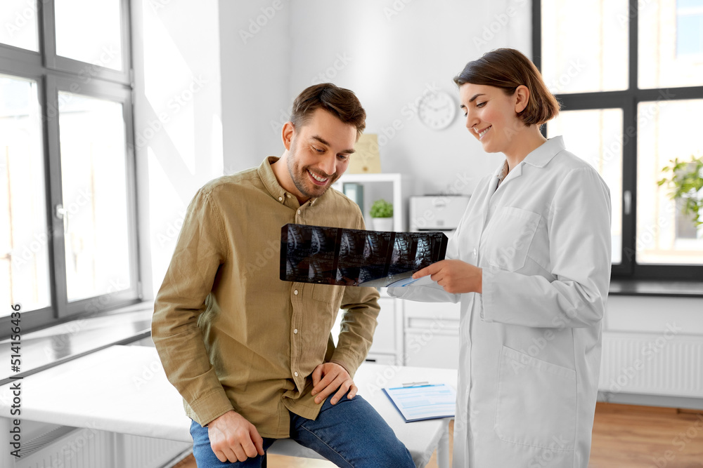 Poster medicine, healthcare and people concept - happy smiling female doctor showing x-ray to male patient at medical office in hospital