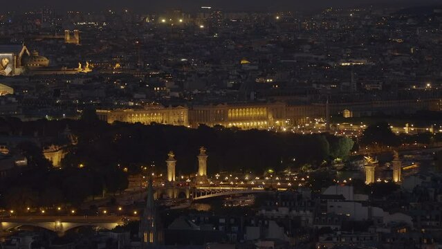 Pont Alexandre III bridge and rooftops at night seen the second floor of the Eiffel Tower in Paris, France