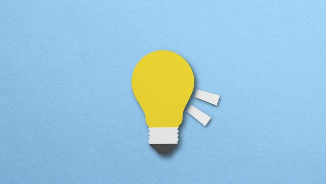 yellow paper light bulb emitting light concept idea. stop motion Design