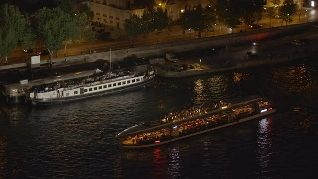 Bateau Mouche excursion boat sailing on the Seine at night in Paris, France