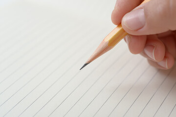 ノートに書く女性の手