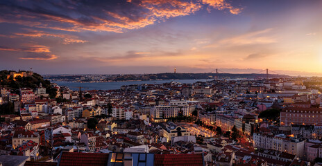 Panoramic view of the illuminated cityscape of Lisbon, Portugal, with Sao Jorge Castle and the Alfama district until the Tagus river just after sunset