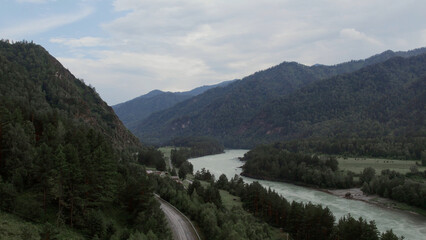 Mountains of Altai and traffic cars on road beside of Katun river