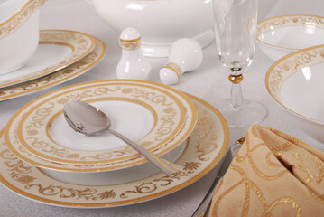 Elegant table setting with luxury china dinnerware. Golden design porcelain dishes.
