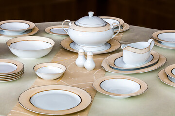 Elegant table setting with luxury china dinnerware. Golden design porcelain dishes.