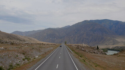 Chuya highway with traffic cars and mountains in valley of Altai