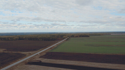 Green and brown rural fields with blue sky in autumn time in Ural