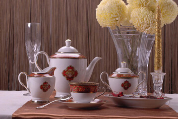 Beautiful bone-china tea set with tea pot and cups and saucers. Minimal and elegant design.