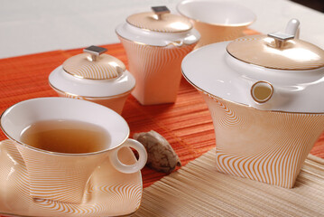 Beautiful bone-china tea set with tea pot and cups and saucers Elegant and minimal design.