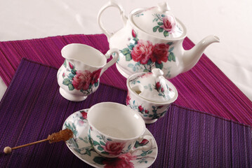 Beautiful bone-china tea set with tea pot and cups and saucers. Minimal and elegant design.