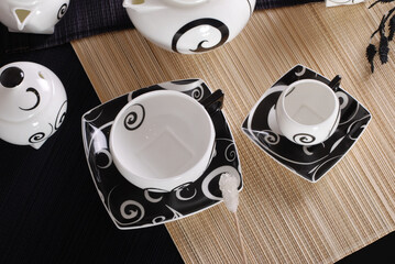 Beautiful bone-china tea set with tea pot and cups and saucers. Minimal and elegant design.